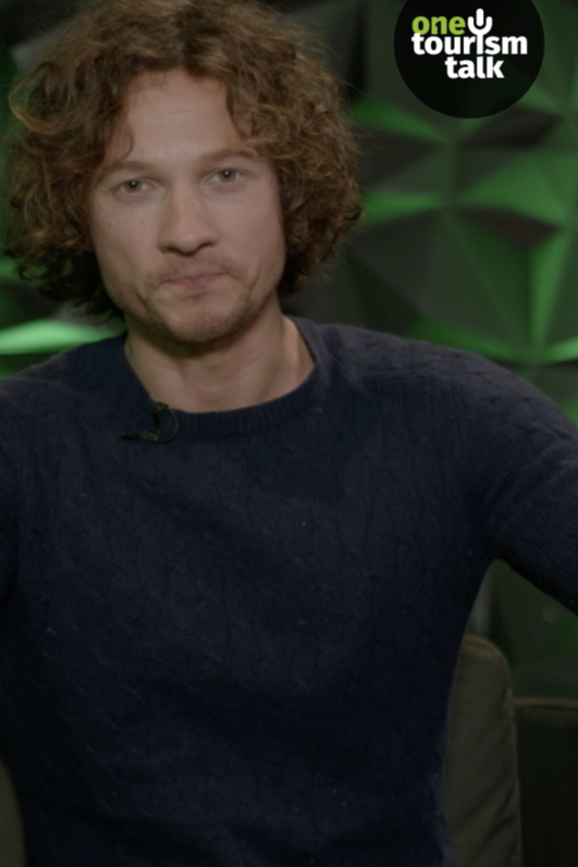Talkshowgast vor grüner Studiokulisse