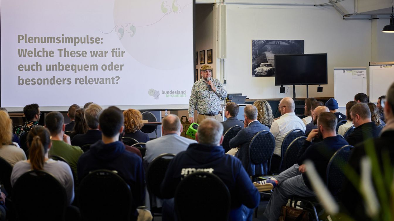 Moderator Florian Bauhuber vor den Besucher:innen des 1. Bundesland KI-Summits